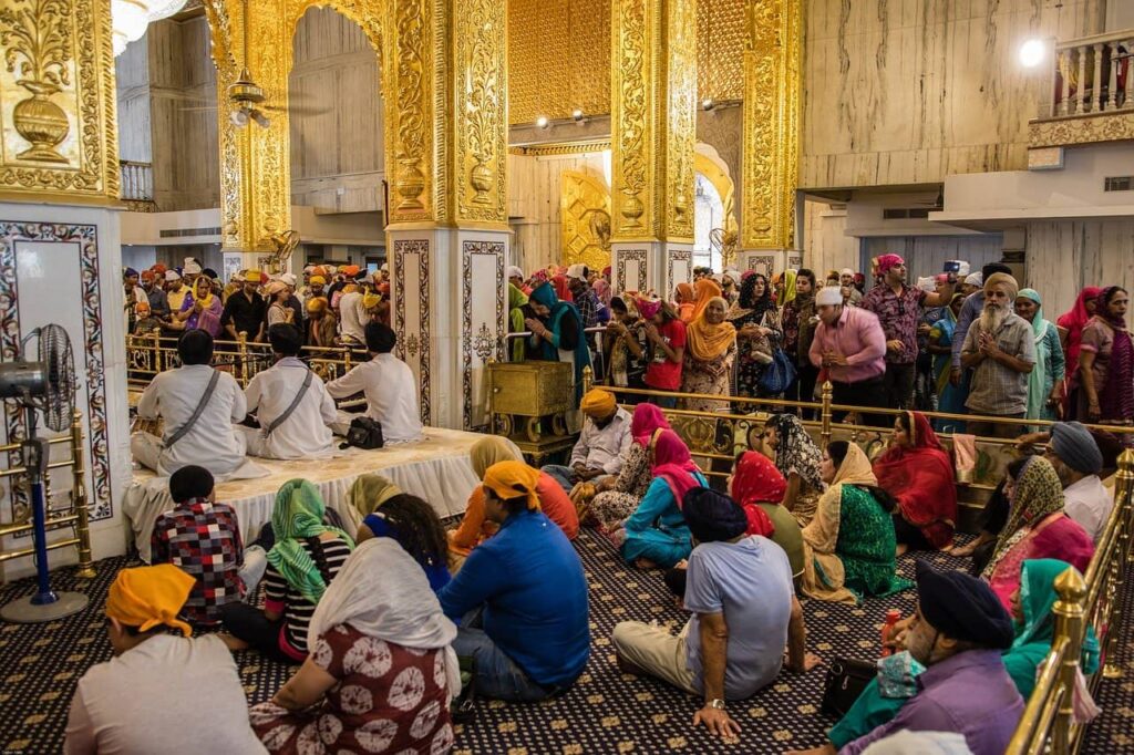 Inside Bangla Sahib Gurudwara, where people doing worship and listening to spiritual songs.