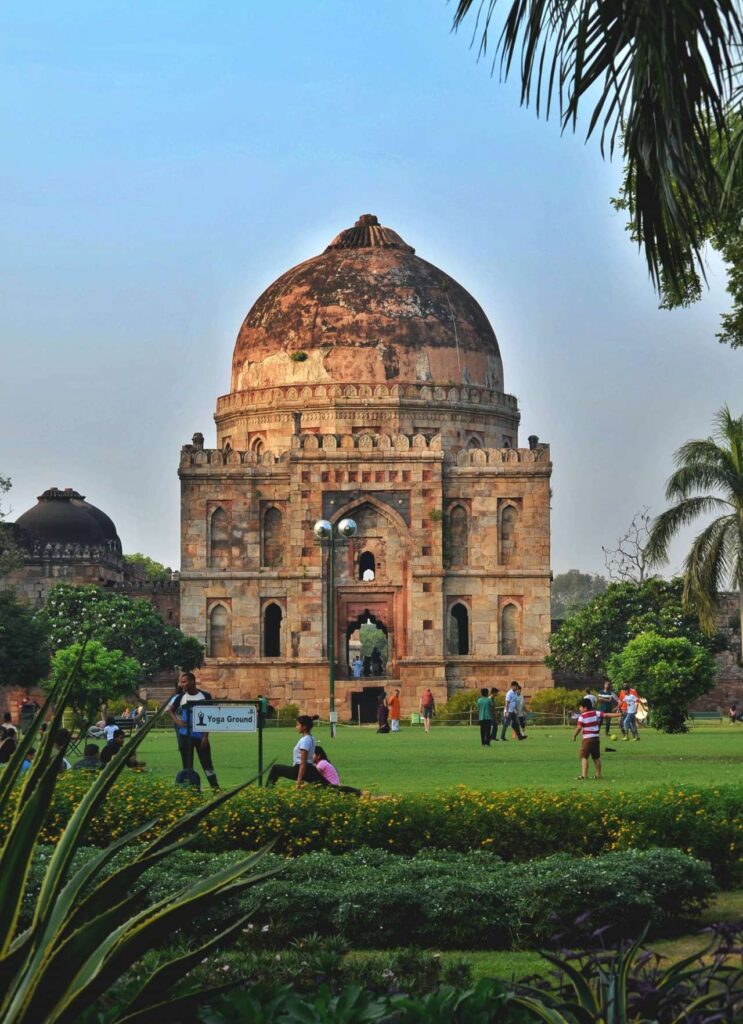 Mughal structure inside Lodhi Garden, and green space where people are doing exercise.