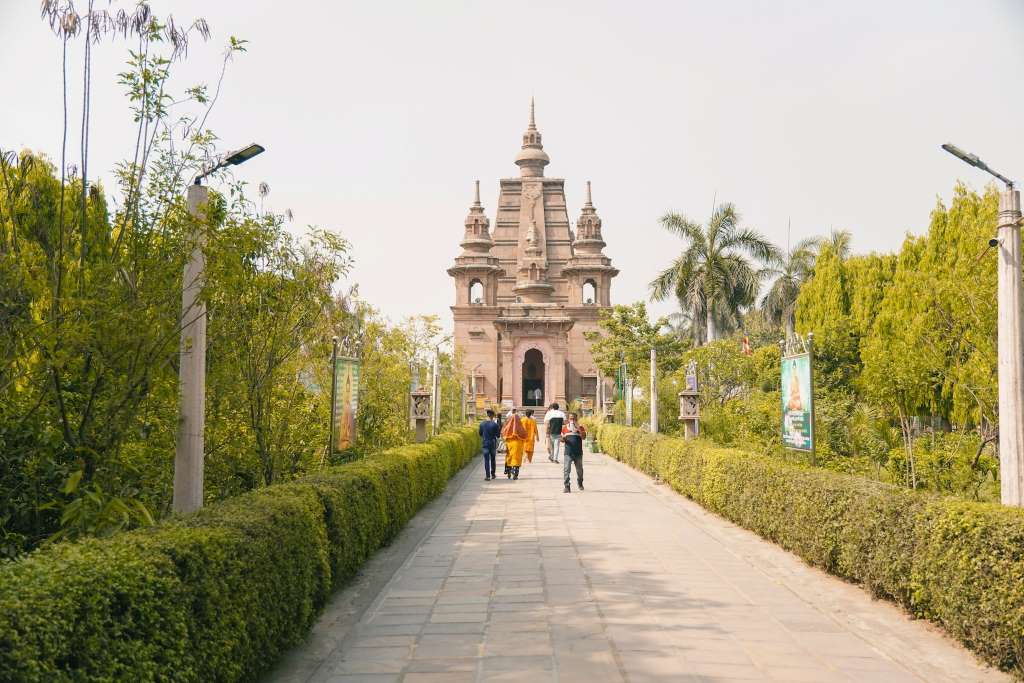People are walking the the path leading to the entrance of Mahabodhi socity temple in sarnath.